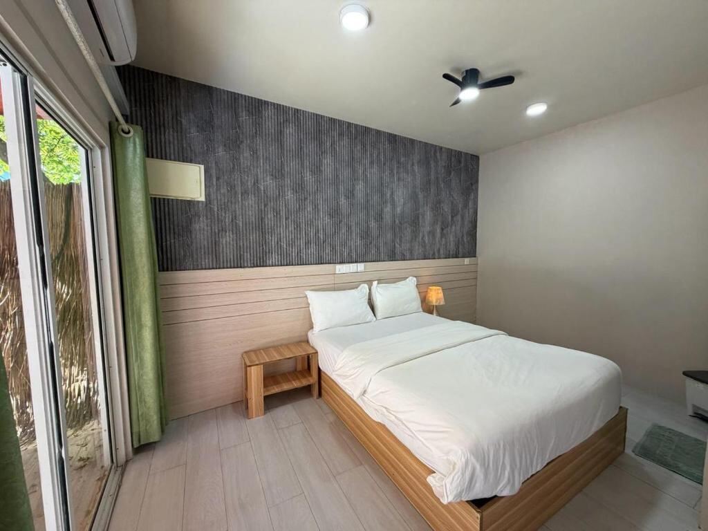 Bright room with wooden bed and view to the garden